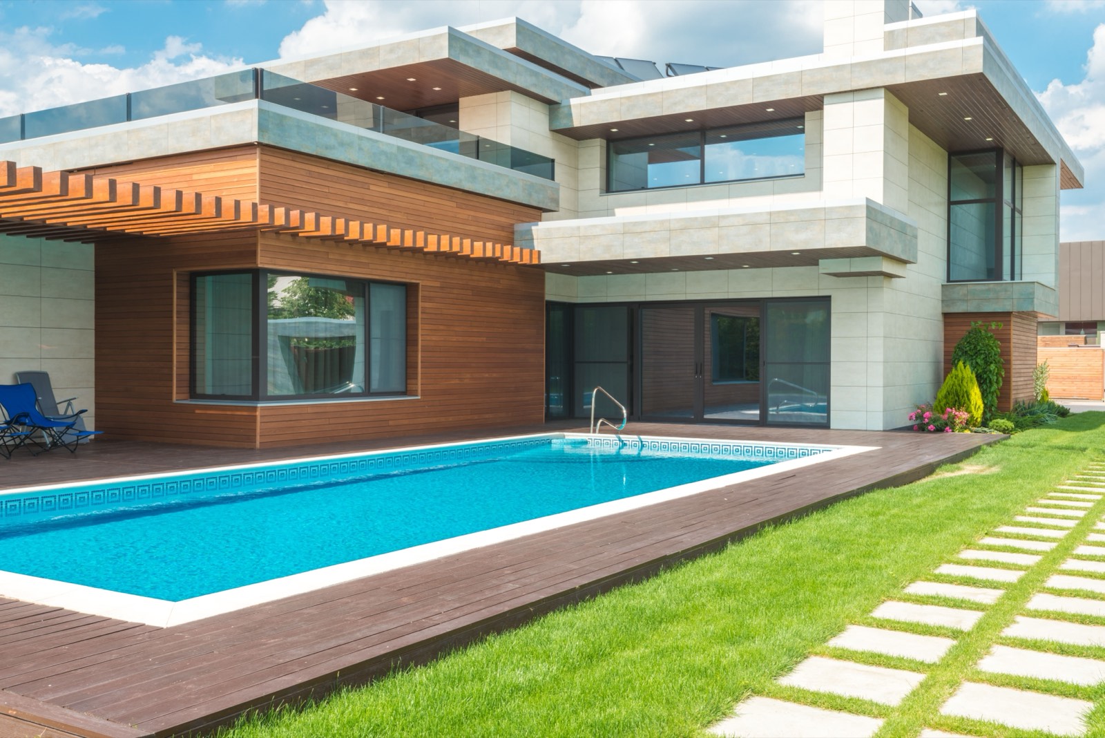 Modern residential home with a custom concrete pool and timber deck