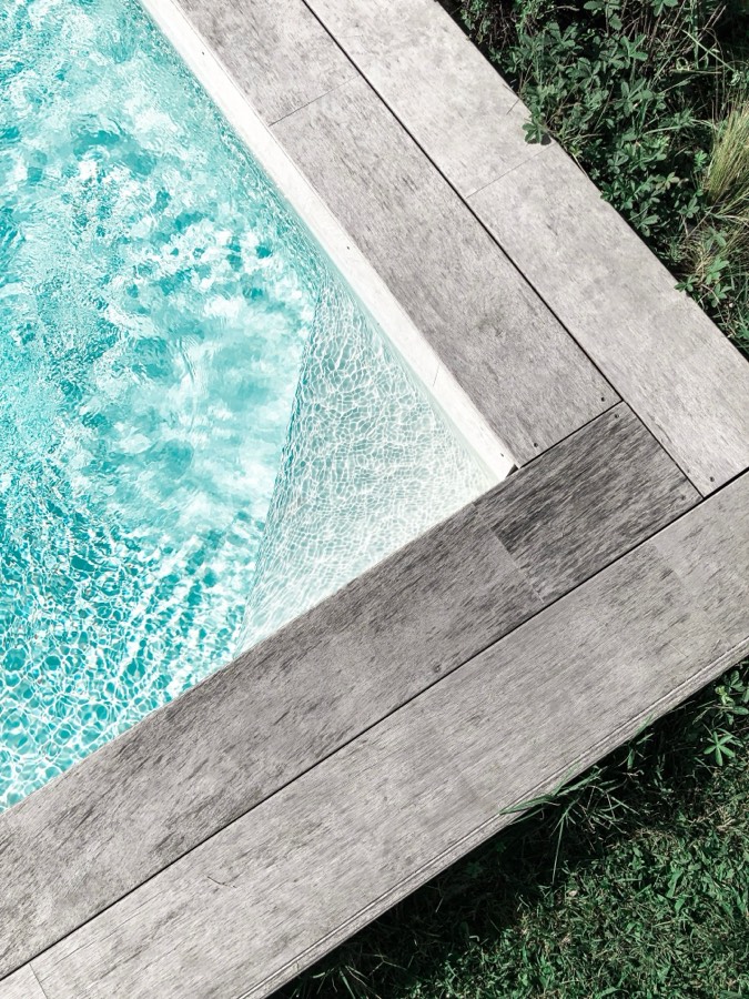 Aerial view of a pool corner framed by timber decking